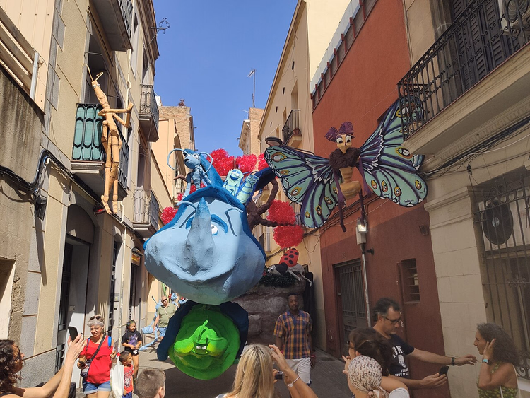 Pyntet gate i Gràcia med gigantfigurer og tilskuere