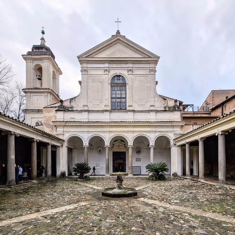 Atrium med fontene og fasaden til basilikaen San Clemente
