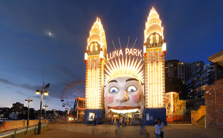 Opplyst inngangsparti til Sydneys Luna Park med et smilende ansikt om natten