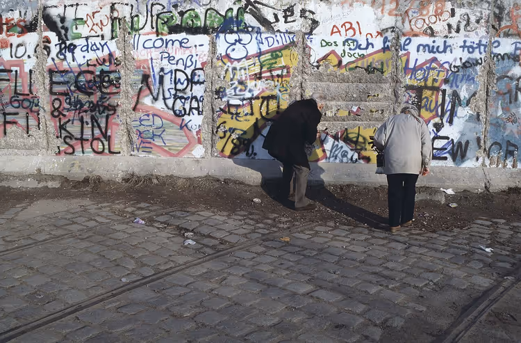 Boyalı Berlin Duvarı önündeki insanlar