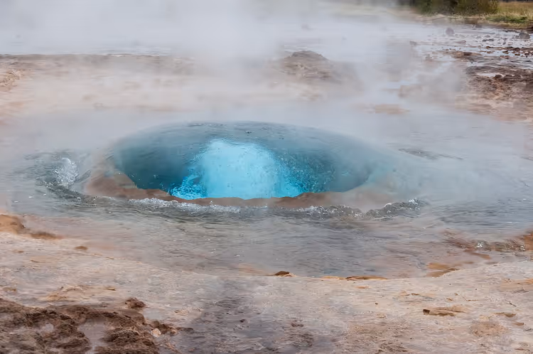 Parktaki Strokkur gayzerinin mavi kaynayan krateri