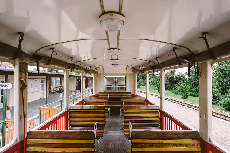 Interieur van een wagon van de Kinderspoorweg met houten banken