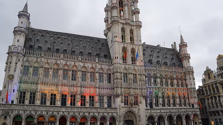 Grand-Place'da projeksiyonlar ve bayraklarla Brüksel Belediye Binası
