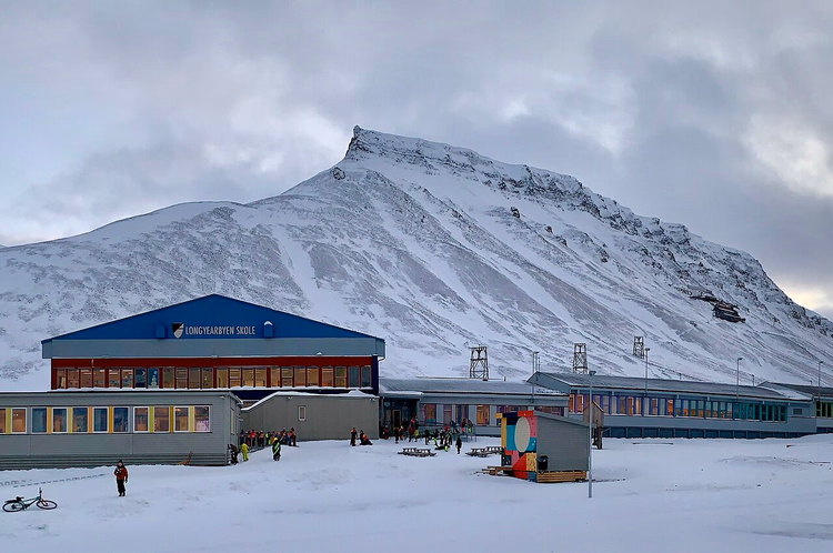 Longyearbyen skole med snødekt fjell i bakgrunnen