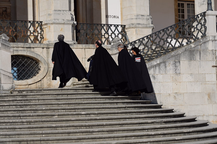 Professoren in Talaren auf der Treppe der Universität Coimbra