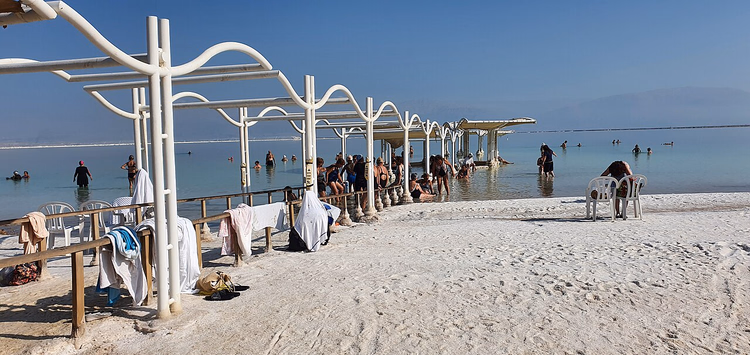 Ein Bokek'te gölgeliklerle Ölü Deniz plajı