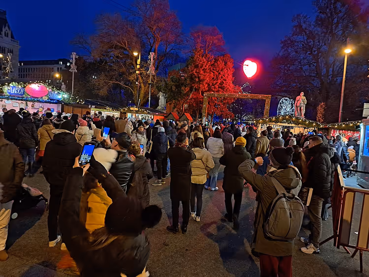 Folkemengde på et julemarked, boder og røde lys