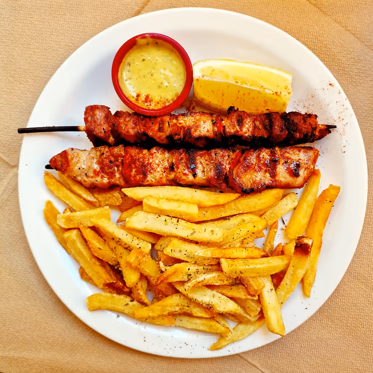şişte souvlaki, patates kızartması ve sos