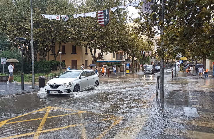Oversvømt gate i Salou med bil og fotgjengere