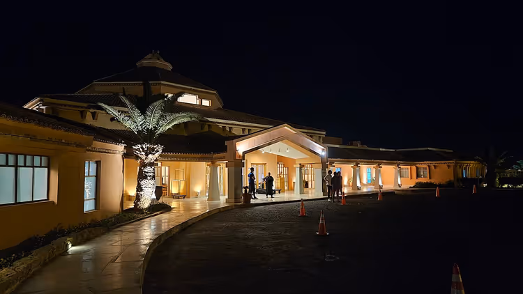 Işıklandırılmış tente ve palmiye ağacıyla Mövenpick otelinin gece girişi