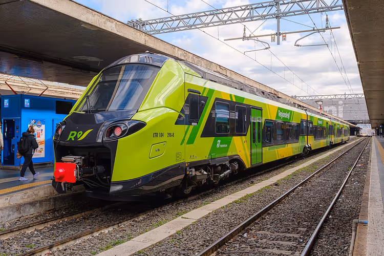 Groen-gele Trenitalia Regionale-trein op een station