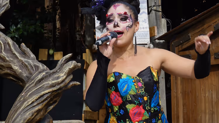 Sahnede şarkı söyleyen Katrina kostümlü bir performans sanatçısı
