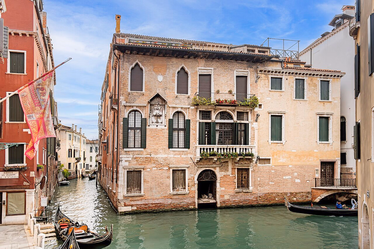 Gotischer Palazzo an einem Kanal mit Gondeln in Castello