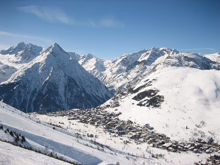Das Dorf Les Deux Alpes umgeben von schneebedeckten Bergen