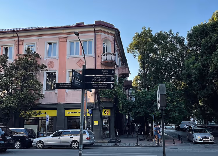Rosafarbenes Gebäude an einer Straßenecke in Batumi