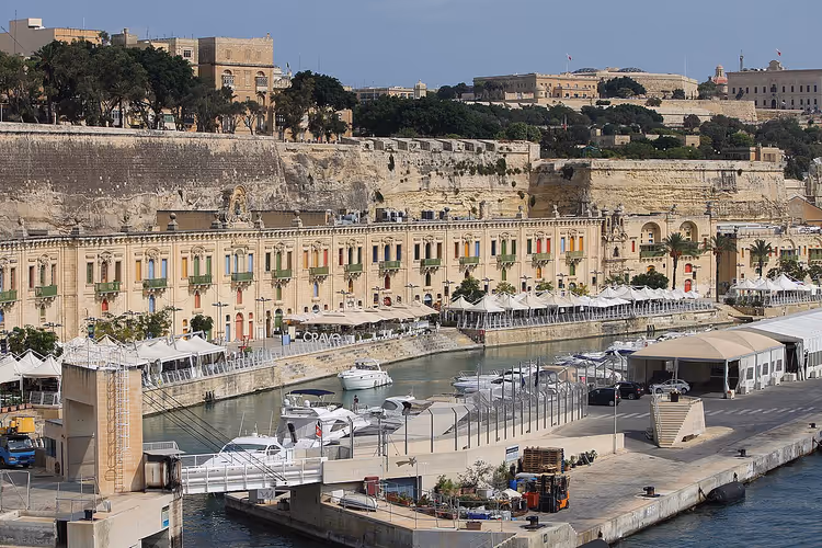 Sjøkanten i Valletta med dokk, båter og parasoller