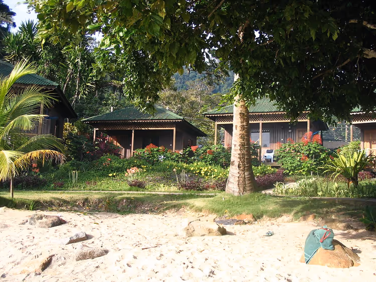 Strand met chalets en tropische bomen in Air Batang