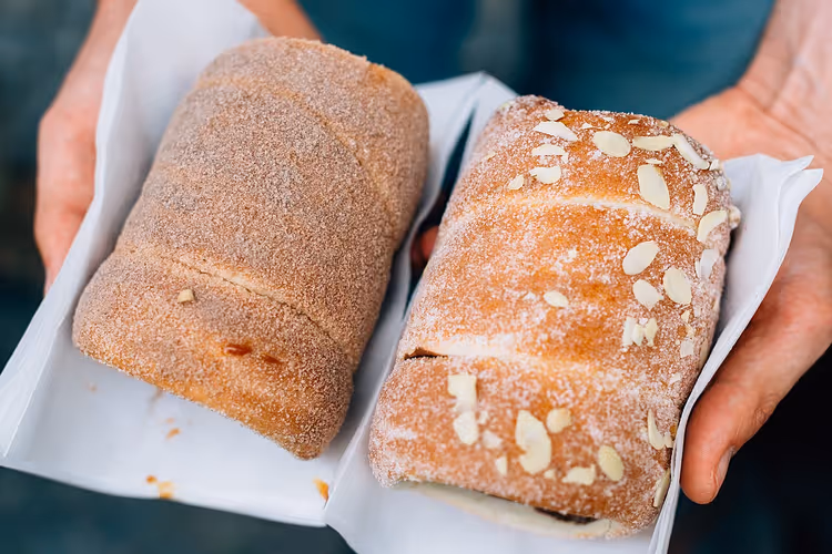 To trdelnik med sukker og mandler i hendene