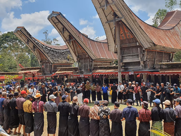 Tongkonan-Häuser und versammelte Menschen in Tana Toraja