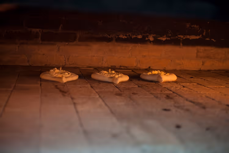 Fırında ahşap masada üç Adjar khachapuri