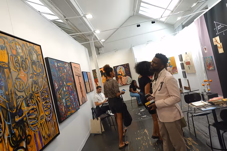 Mensen bekijken schilderijen op een kunstbeurs