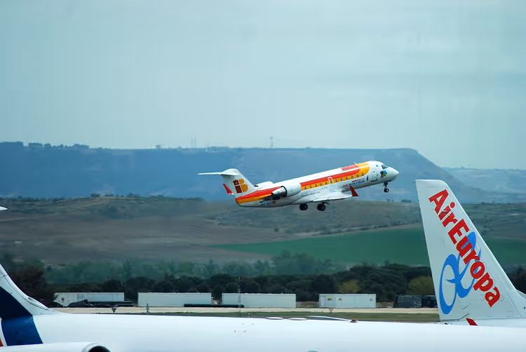 Aereo Iberia che decolla sopra il piazzale dell'aeroporto