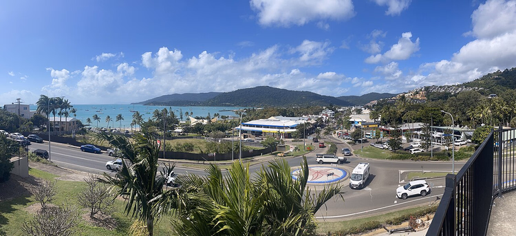 Panorama over Airlie Beach med bukt og palmer