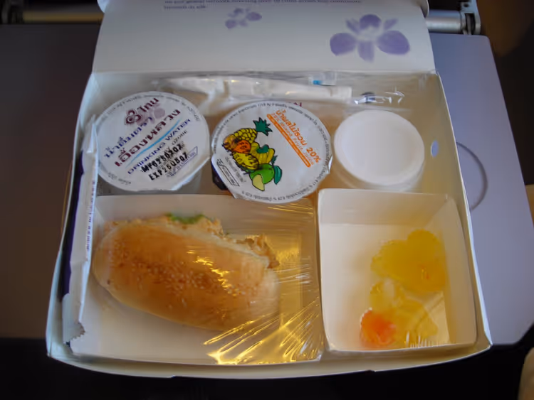 Flymatbrett med sandwich og frukt