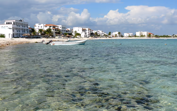 Akumal Koyu'nda bir tekne ve beyaz oteller