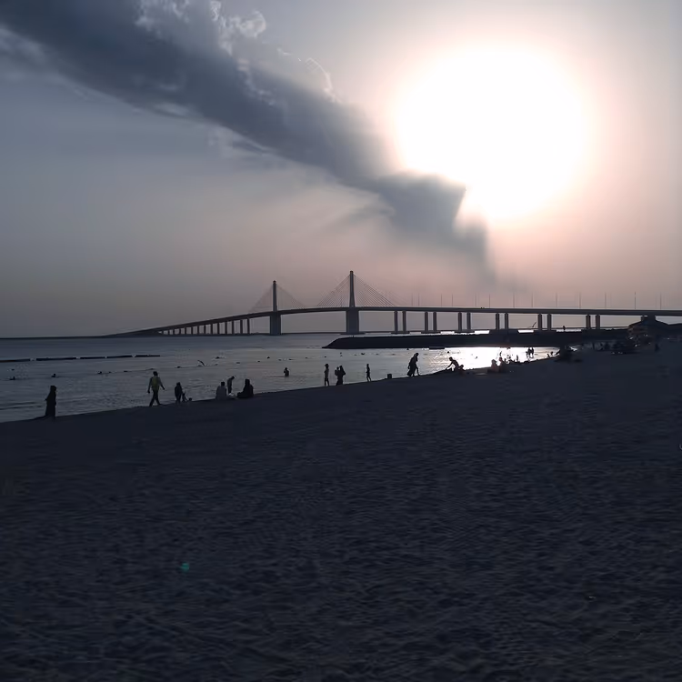 Al Bateen-stranden i solnedgang med bro