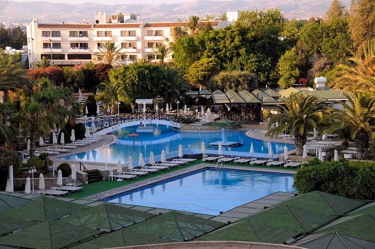 Zwembaden en gebouwen van het Aloe Hotel tussen de palmen