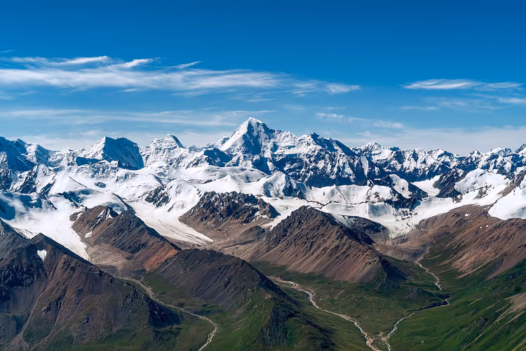 Den snødekte Khan Tengri-toppen over grønne alpine enger