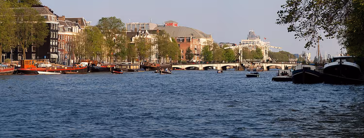 Blick auf die Amstel mit einer Brücke und Booten