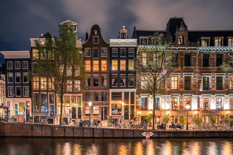 Amsterdamer Grachten bei Nacht mit beleuchteten Häusern