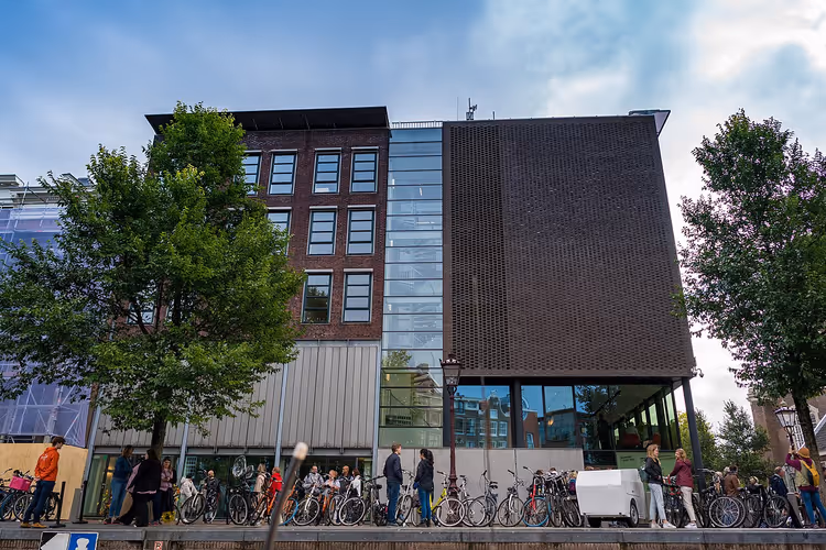 Fassade des Anne-Frank-Hauses mit Fahrrädern und Menschen