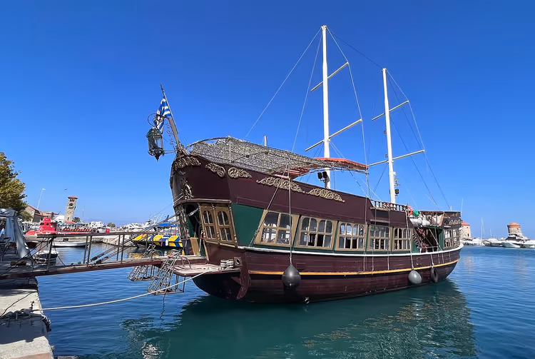 قارب سياحي خشبي بأشرعة في الميناء