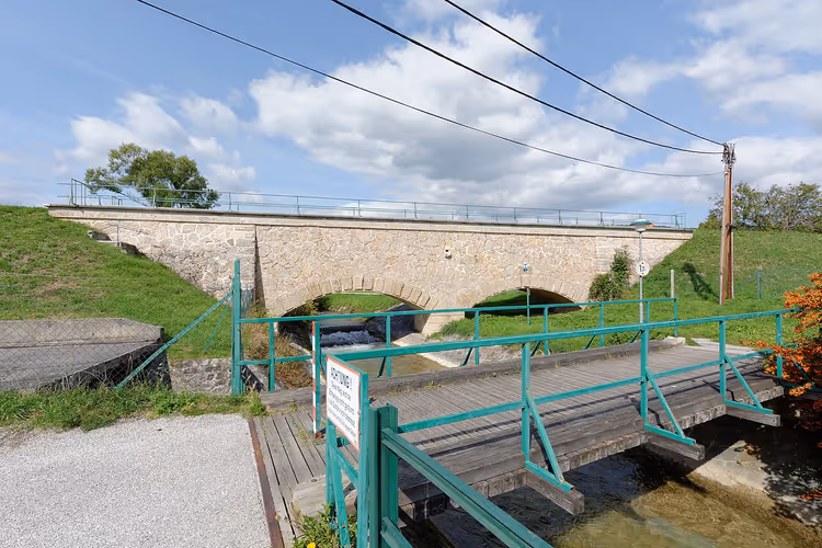Stenen aquaduct met bogen over een beek