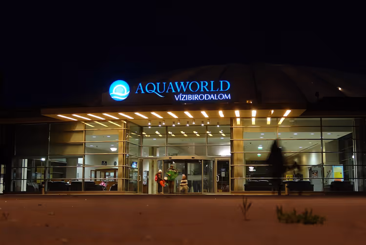Nachtelijke ingang van waterpark Aquaworld met verlicht uithangbord