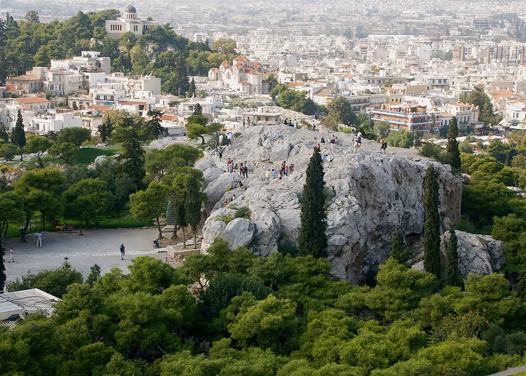Areopagos-fjellet med folk mot Athens bakgrunn