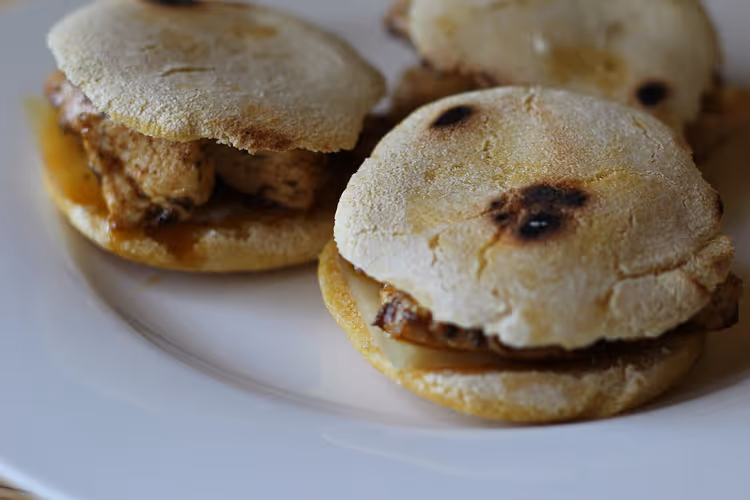 Arepas med fyll på en hvit tallerken