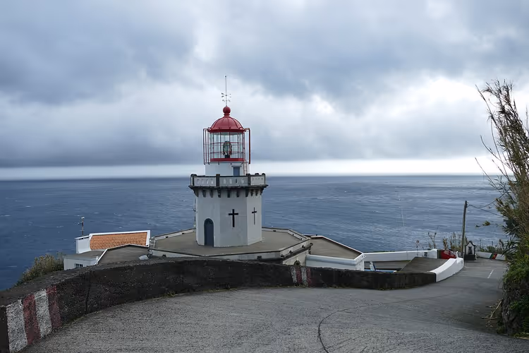 Vuurtoren van Arnel op een rotsachtige landtong aan de oceaan