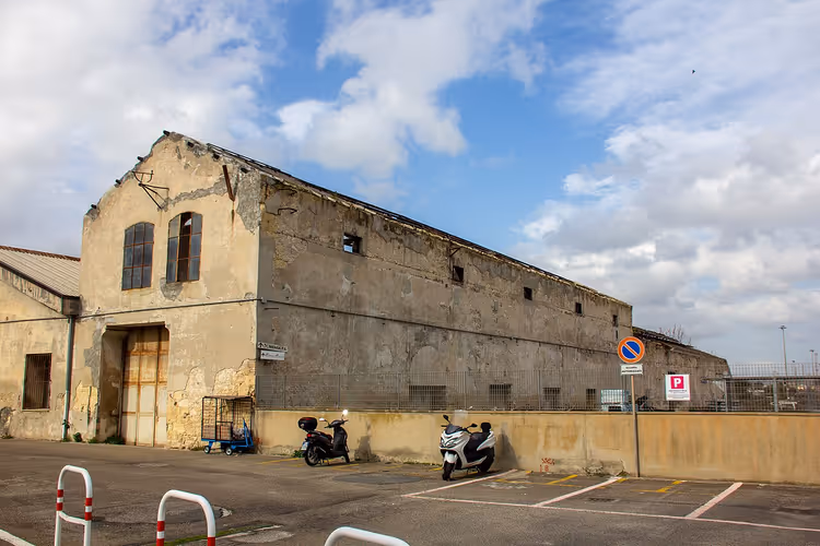 Oud gebouw en parkeerplaats met scooters in Cagliari