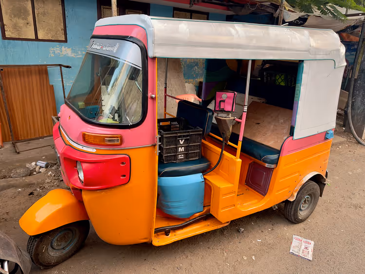 Oranjerode Bajaj-tuktuk met een witte kap