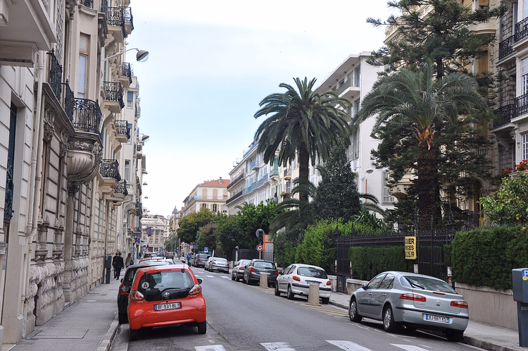 Straße in Nizza mit Palmen und historischen Gebäuden