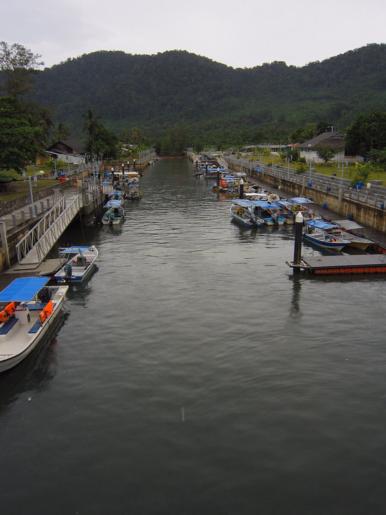 Boten in Tekek Marina met bergen op de achtergrond