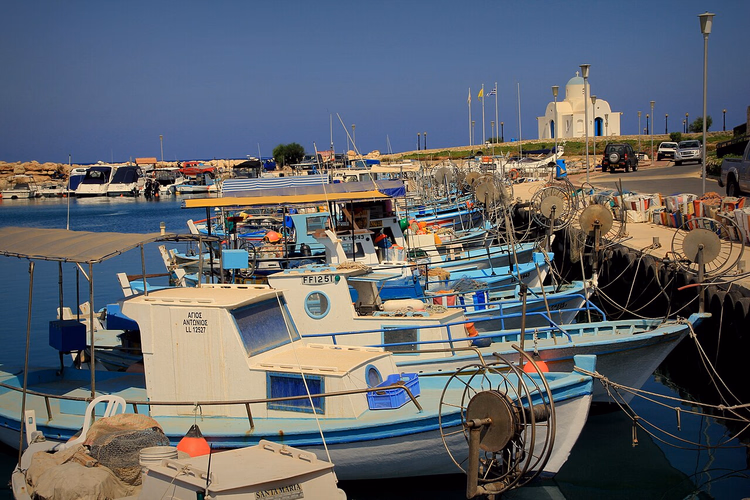 Vissersboten in de haven van Ayia Napa bij een kapel