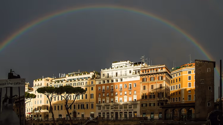 Arco-íris sobre edifícios romanos com um letreiro da Azienda Tessile Romana