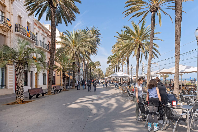Palmekledde Rambla i Badalona med kafeer ved sjøen