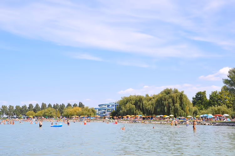 Strand am Balaton mit Badenden und grünlichem Wasser