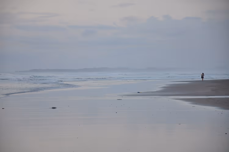 Bali strand bij zonsopgang, golven en een persoon